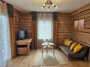 a living room with a couch and a tv at Metsavahi puhketalu in Kaevussaare