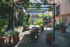 een tuin met een pergola, een tafel en potplanten bij Appartamento per 4 - Linea Rossa Precotto e Gorla in Milaan