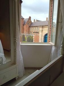 une fenêtre ouverte avec vue sur un bâtiment dans l'établissement Le 304 Douai, à Douai