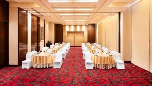 a banquet hall with tables and white chairs at Courtyard by Marriott Pune Hinjewadi in Pune +35 photos