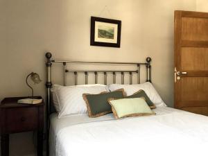 a bedroom with a bed with pillows on it at La Petite Maison à Beaulieu in Beaulieu-sur-Dordogne