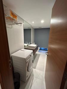 a bathroom with a washing machine and a sink at FlowerGod PentStudio Tay Ho Hanoi in Hanoi