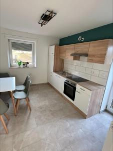 een keuken met witte kasten en een tafel en een stoel bij Doppelzimmer 3 - neu renoviert in Dinkelsbühl