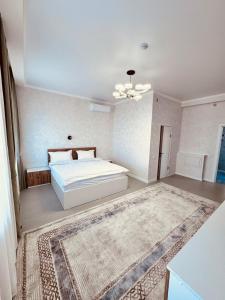 Hotel Bereket Karaganda في كاراغاندي: غرفة نوم بسرير ابيض وسجادة