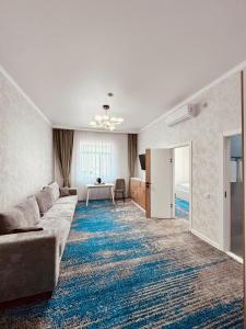 Hotel Bereket Karaganda في كاراغاندي: غرفة معيشة مع أريكة وطاولة