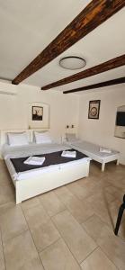 a white bedroom with a large bed and a table at Apartmány Pulgary in Bulhary