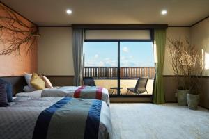 a hotel room with two beds and a balcony at Villa Ryusei in Ugata