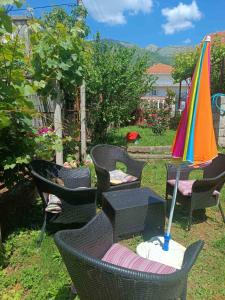 a group of chairs and umbrellas in a yard at APARTMAN ČAROLIJA TREBINJE in Trebinje