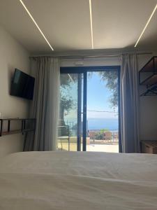 Lithitsa Lofts and Suites في بارغا: غرفة نوم مع سرير وإطلالة على المحيط