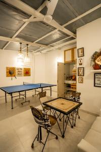 - une table de ping-pong et des chaises dans la chambre dans l'établissement Kenwoods Farmstay, Zadpolli - 6BHK Villa with Swimming Pool, à Kudān