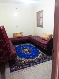 a living room with a couch and a blue rug at hotel appart inezgane agadir in Inezgane