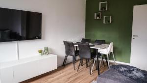 ein Esszimmer mit einem Tisch mit Stühlen und einem TV in der Unterkunft Exklusive Ferien-Appartements Di Marino in Schönwald