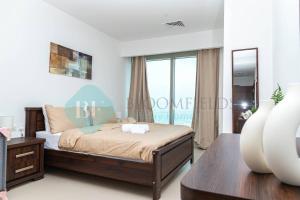 um quarto com uma cama e uma grande janela em Bloomfields - 1br Amazing Sky View At Gate Tower em Abu Dhabi