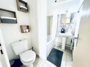 a white bathroom with a toilet and a sink at COSY STUDIO in the center of Fontainebleau in Fontainebleau