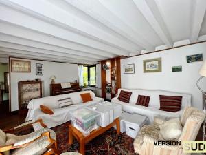 una sala de estar con 2 sofás blancos y una mesa. en Version Sud- Villa avec piscine végétal, en La Valette-du-Var