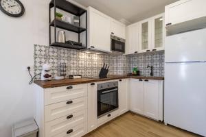 La cuisine est équipée de placards blancs et d'un réfrigérateur blanc. dans l'établissement Cosy apartment in Albufeira, OURA ST, à Albufeira