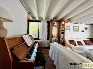 sala de estar con piano y sofá en Version Sud- Villa avec piscine végétal, en La Valette-du-Var