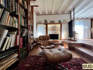 una sala de estar con una silla de cuero y libros en Version Sud- Villa avec piscine végétal, en La Valette-du-Var