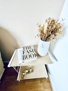 a table with a book and a vase on it at COSY STUDIO in the center of Fontainebleau in Fontainebleau