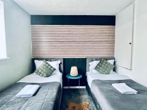 2 camas en una habitación pequeña con silla en Holiday Home in Canterbury, en Kent