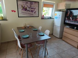 a kitchen with a table with chairs and a refrigerator at Megan turystyka in Gdańsk