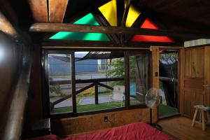 a stained glass window in a room with a bed at Cabaña Los Robles YOLI in Colonia del Sacramento