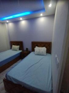 a bedroom with two beds and a blue light at مدينتى in Madinaty