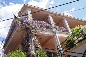 a house with purple flowers on the side of it at EcoHouse Risan Studio in Risan