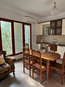 a kitchen with a wooden dining room table and chairs at Apartament Gjiri i Lalëzit in Draç