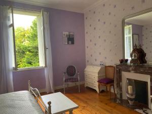 um quarto com paredes roxas, uma lareira e um espelho em Domaine de la Perthuiserie em Saint-Porchaire