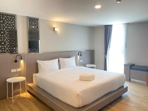 1 dormitorio con 1 cama grande con sábanas blancas en วัน บัดเจท ตาก แม่สอด - One budget hotel Tak Maesot en Mae Sot