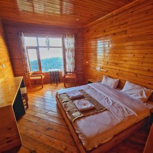 a bedroom with a large bed in a wooden room at EDM Hostel in Kangra