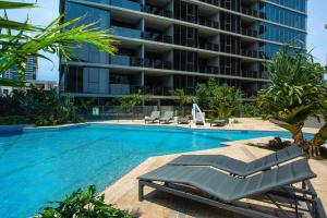 a swimming pool next to a large building at Stylish central apartment w pool, gym and more in Brisbane