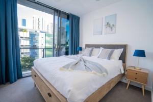 a bedroom with a large bed and a large window at Stylish central apartment w pool, gym and more in Brisbane +29 photos