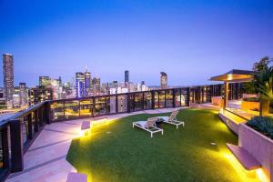 a rooftop patio with a green lawn on a building at Stylish central apartment w pool, gym and more in Brisbane
