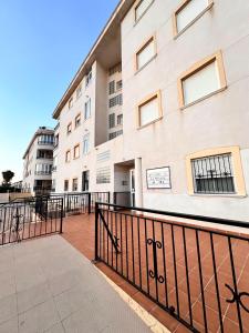 un edificio con una valla negra delante de él en Costa Oasis Residencia La Mirada, en Orihuela Costa