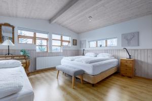 a bedroom with two beds and a desk and windows at Cabin Úthlíð - Birta Rentals in Úthlid