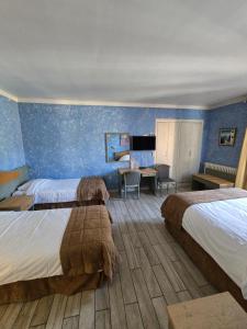 グラースにあるオーベルジュ レ アロームのベッド2台とデスクが備わるホテルルームです。
