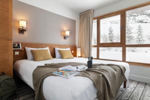 a hotel room with two beds and a window at Résidence Pierre & Vacances Premium Les Terrasses d'Eos in Flaine