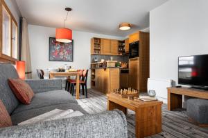 un soggiorno con un divano e un tavolo di Résidence Pierre & Vacances Premium Les Terrasses d'Eos a Flaine Altre 60 foto