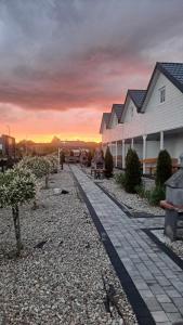 eine Gruppe von Häusern mit Sonnenuntergang im Hintergrund in der Unterkunft Domki Scandinavia in Rowy