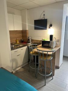 una pequeña cocina con mesa y microondas en Résidence Sainte Thérèse - la villa Selva en Lourdes