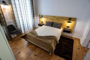 1 dormitorio con 1 cama grande y cabecero de madera en Casa Matriarca, en Santa Comba