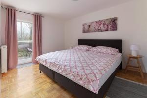 a bedroom with a bed and a window at Cozy Garden Flat in Ljubljana +19 photos