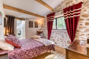a bedroom with a bed and red curtains at La Remise du Bousquet de la Balme in La Tour-sur-Orb