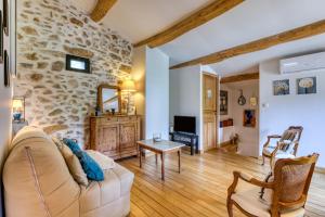 a living room with a stone wall at La Remise du Bousquet de la Balme in La Tour-sur-Orb