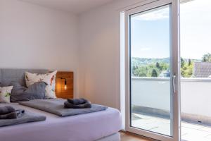 a bedroom with a bed and a large sliding glass door at Penthouse Moos in Moos