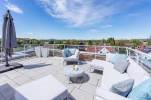 a patio with white furniture and an umbrella on a roof at Penthouse Moos in Moos