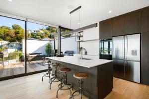 an open kitchen with a island with bar stools at Vista Mare in Wellington