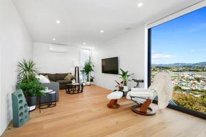 een woonkamer met meubilair en een groot raam bij Vista Mare in Wellington